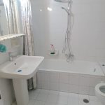 athroom with wall-mounted sink and mirror